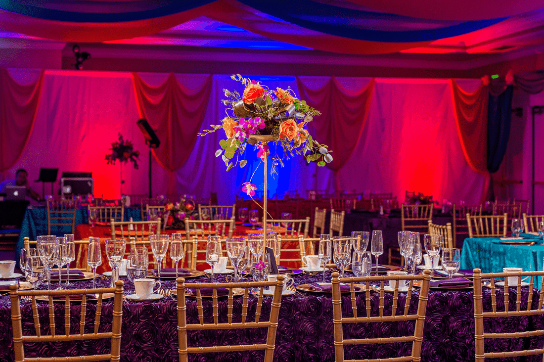 Picture of ballroom draped in colorful Bollywood style, with gold chivari chairs