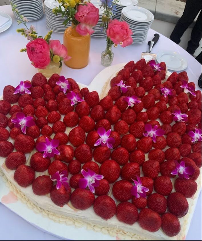 Picture of enormous strawberry-covered sheet cake decorated with fresh orchids